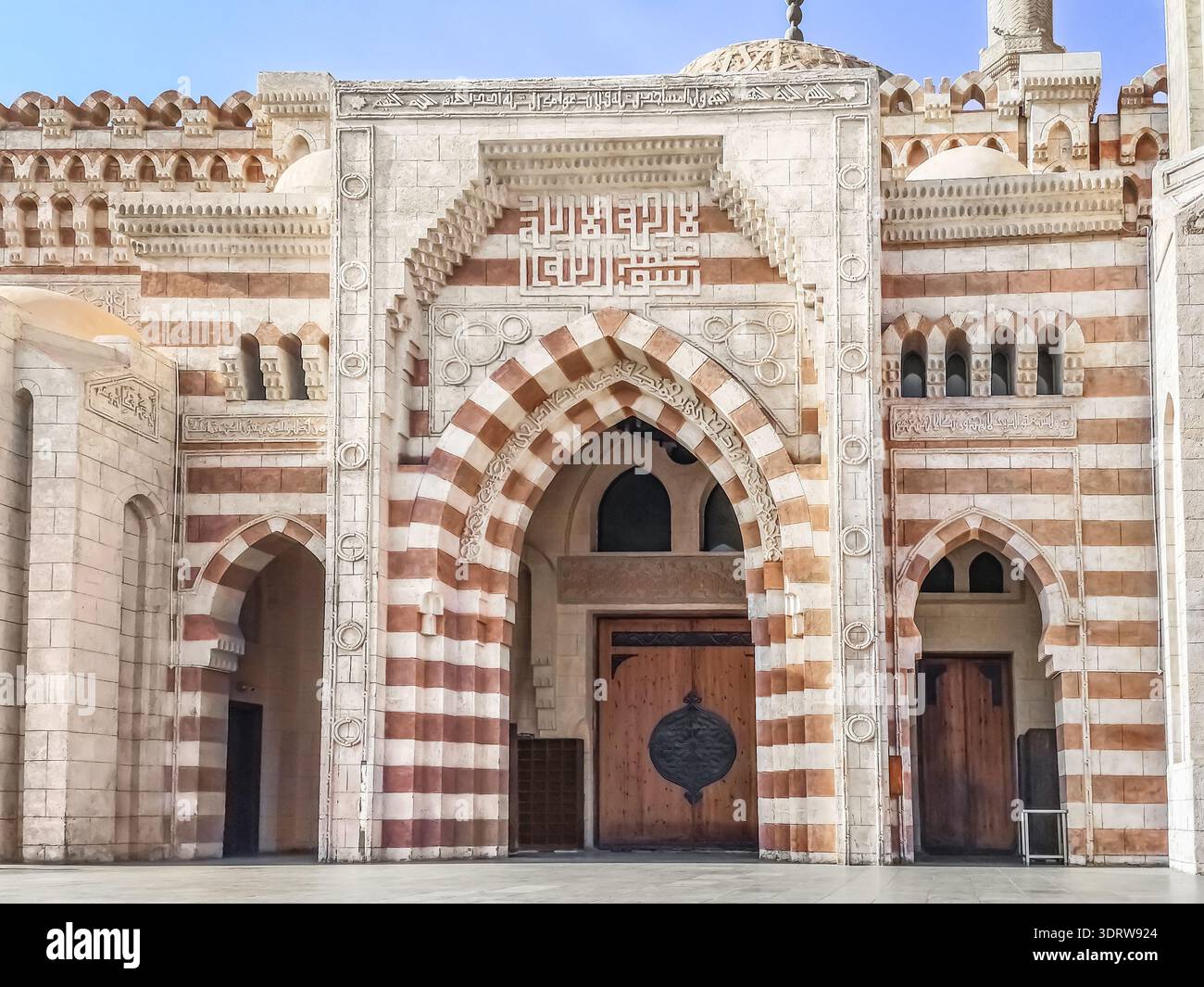 Sharm El Sheikh, Egitto - 18 gennaio 2020: Ingresso alla Moschea al Mustafa a Sharm El Sheikh. Facciata a righe, cancello ad arco e iscrizione araba sul - Immagine stock catturata con smartphone