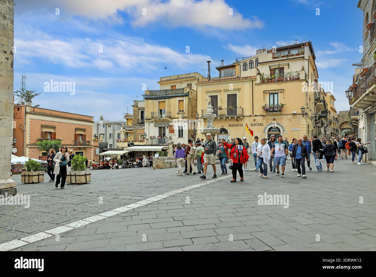 Una guida turistica con i suoi clienti in un tour di Taormina in Piazza del Duomo, Taormina, Sicilia, Italia, Europa Foto Stock