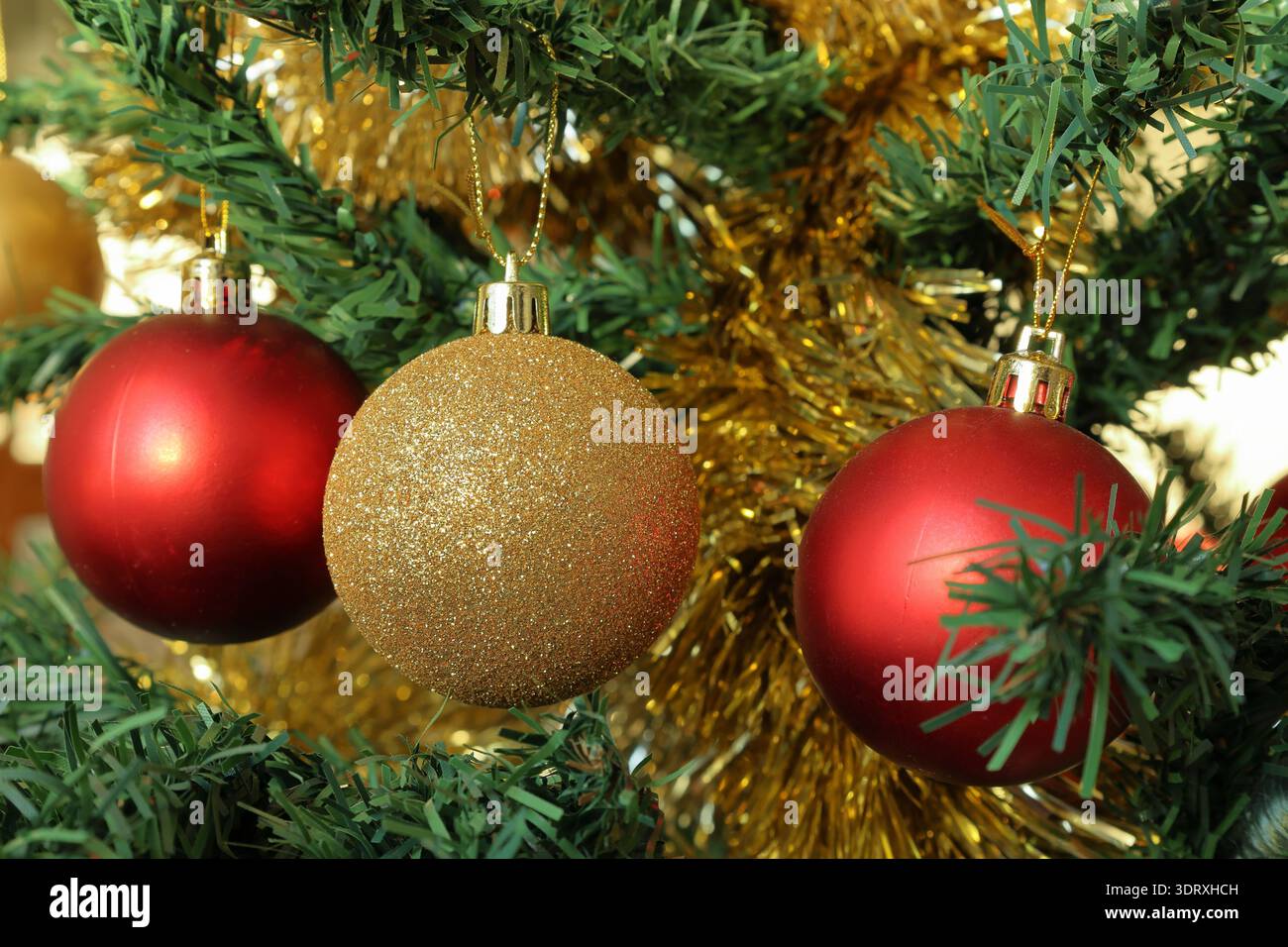 Ornamenti per alberi di Natale. Colori dorati e rossi brillanti. Foto ravvicinata. Foto Stock