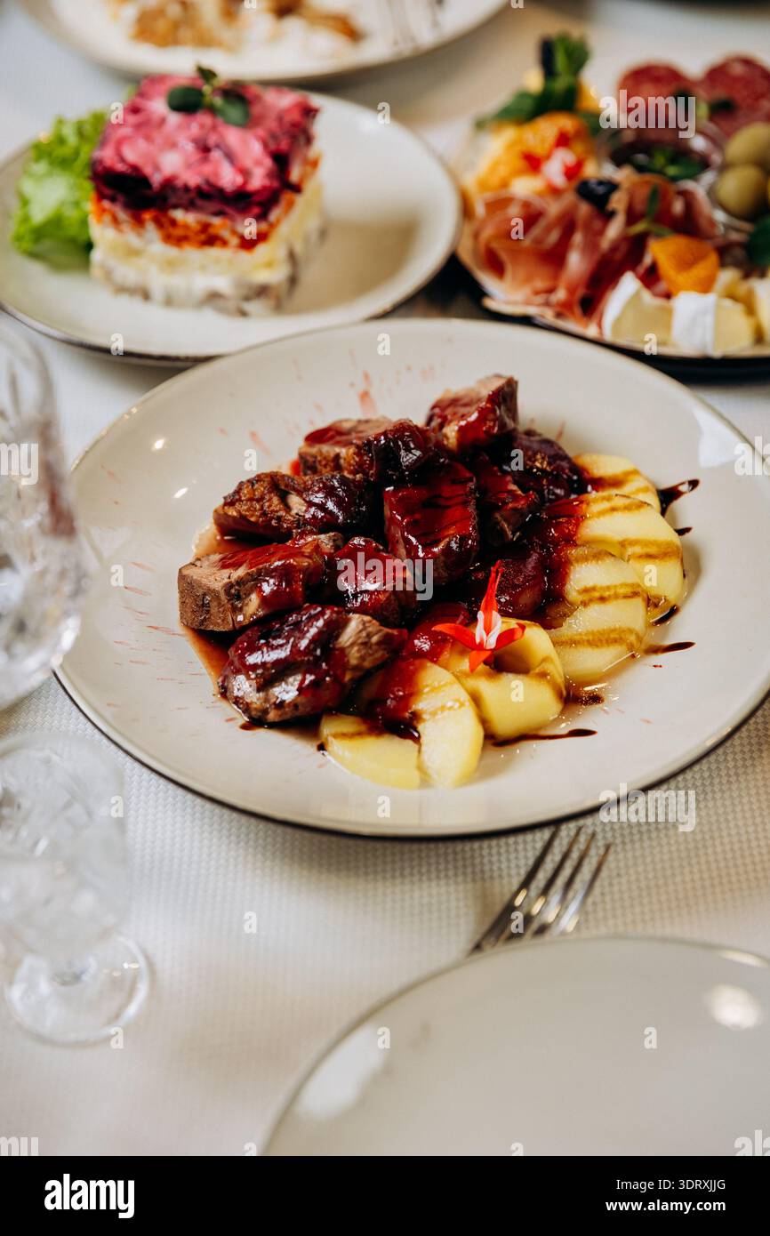 Piatto gourmet di carne con salsa e patate servito presso un elegante ristorante Foto Stock