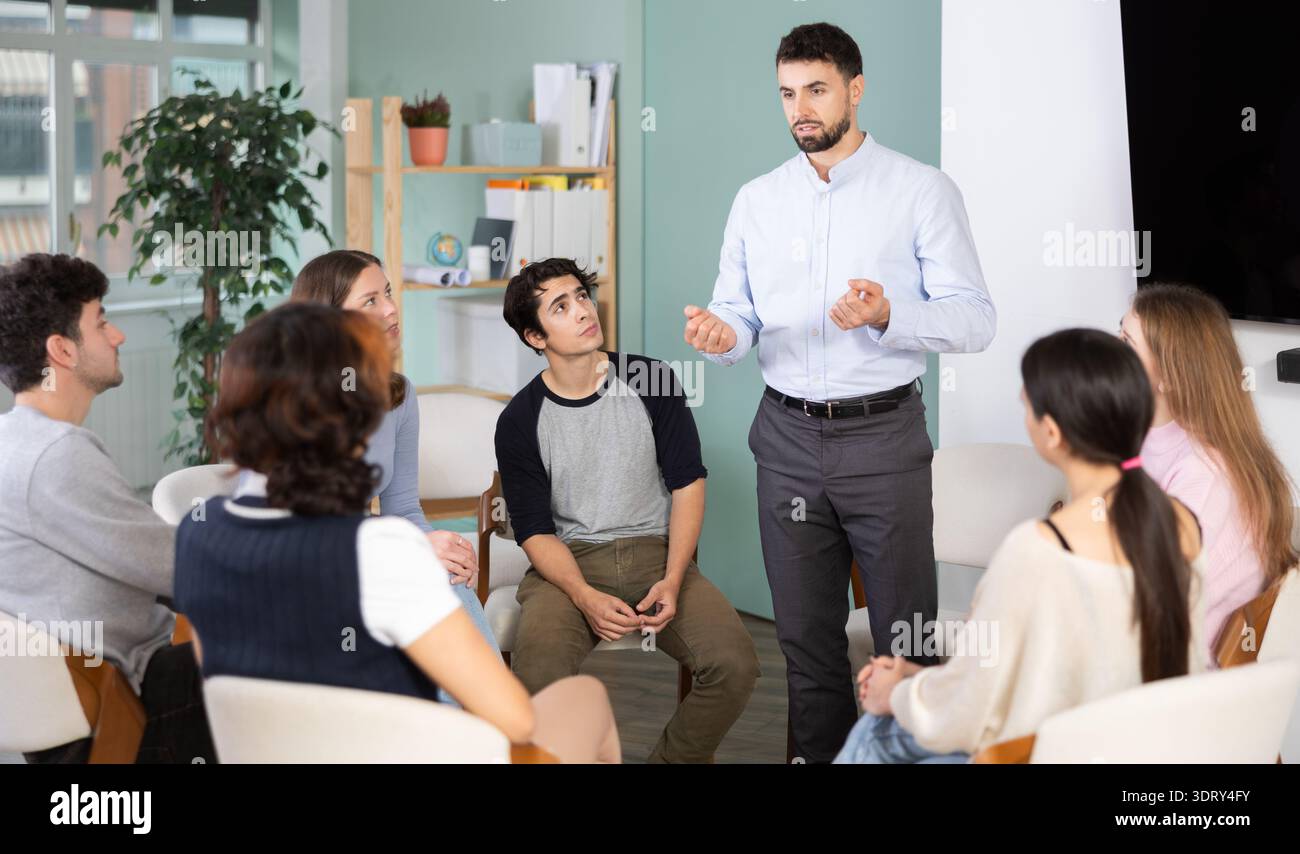 Ragazzi e ragazze sono seduti in cerchio e ascoltano uno dei loro amici compagni di classe Foto Stock