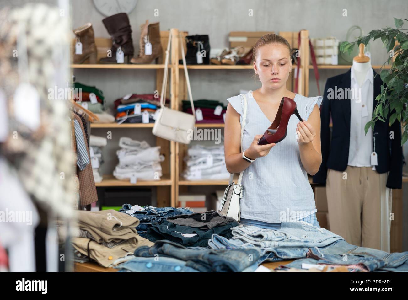 Donna che sceglie le scarpe nel negozio Foto Stock