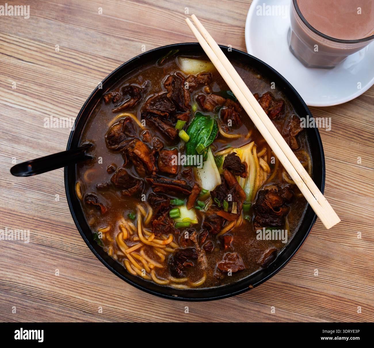 Zuppa di manzo con spaghetti e verdure su fondo di legno Foto Stock