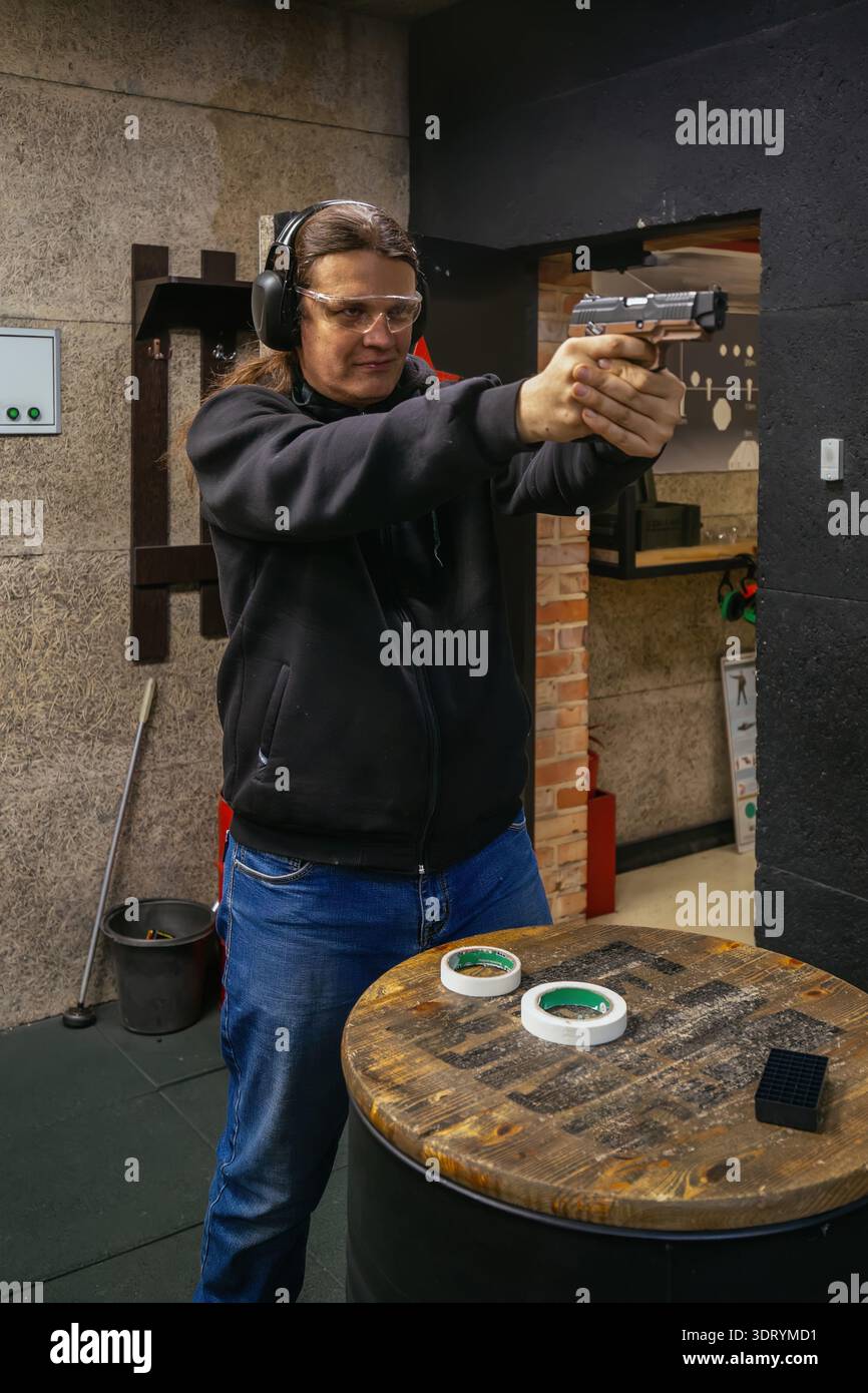 Uomo che punta la pistola nel raggio di tiro. Foto Stock