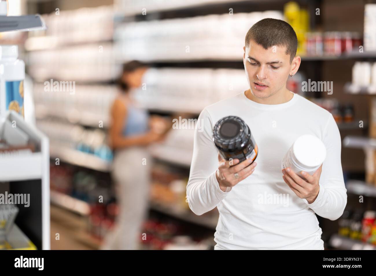 Il ragazzo sceglie la nutrizione sportiva proteica in negozio Foto Stock