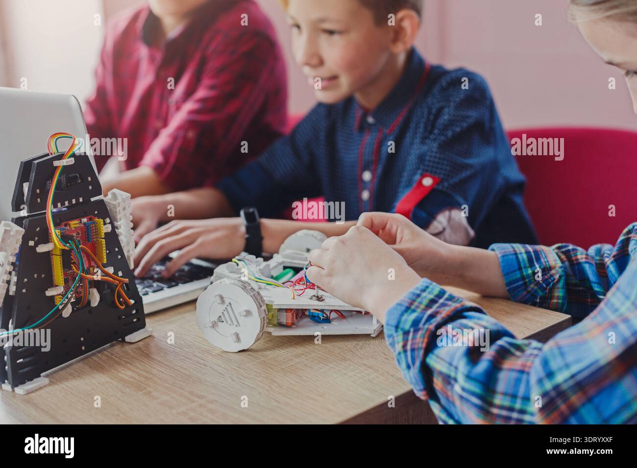 I bambini imparano la robotica attraverso attività pratiche e codifica in un ambiente in aula Foto Stock