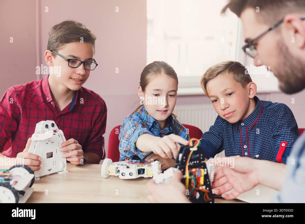 Gli studenti imparano le competenze di codifica e robotica in un workshop in un ambiente in aula Foto Stock