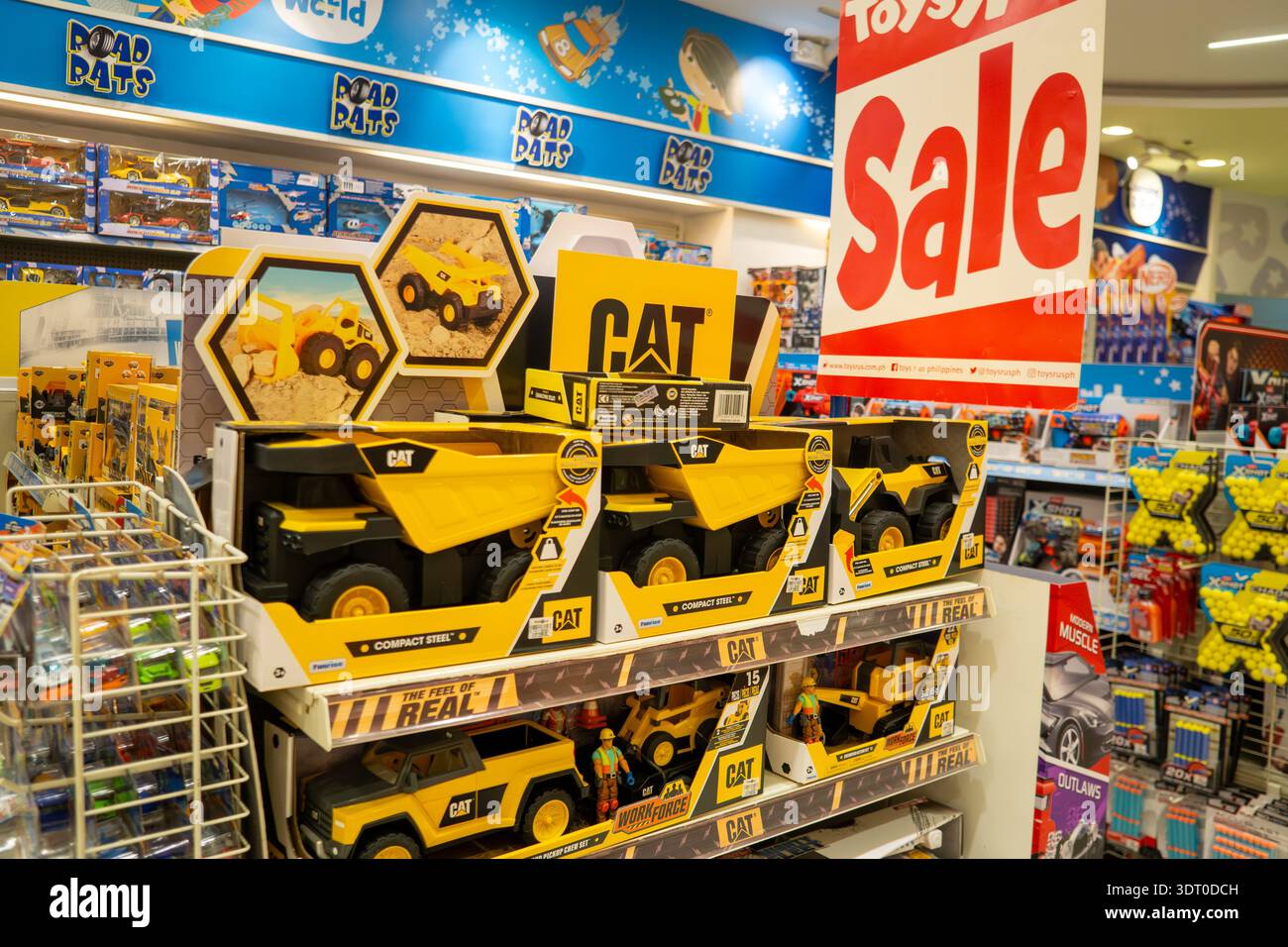 I camion giocattolo CAT Construction sono esposti in vendita all'interno della corsia di vendita dei negozi di giocattoli con articoli di marca e concept di shopping consumer nelle Filippine Foto Stock