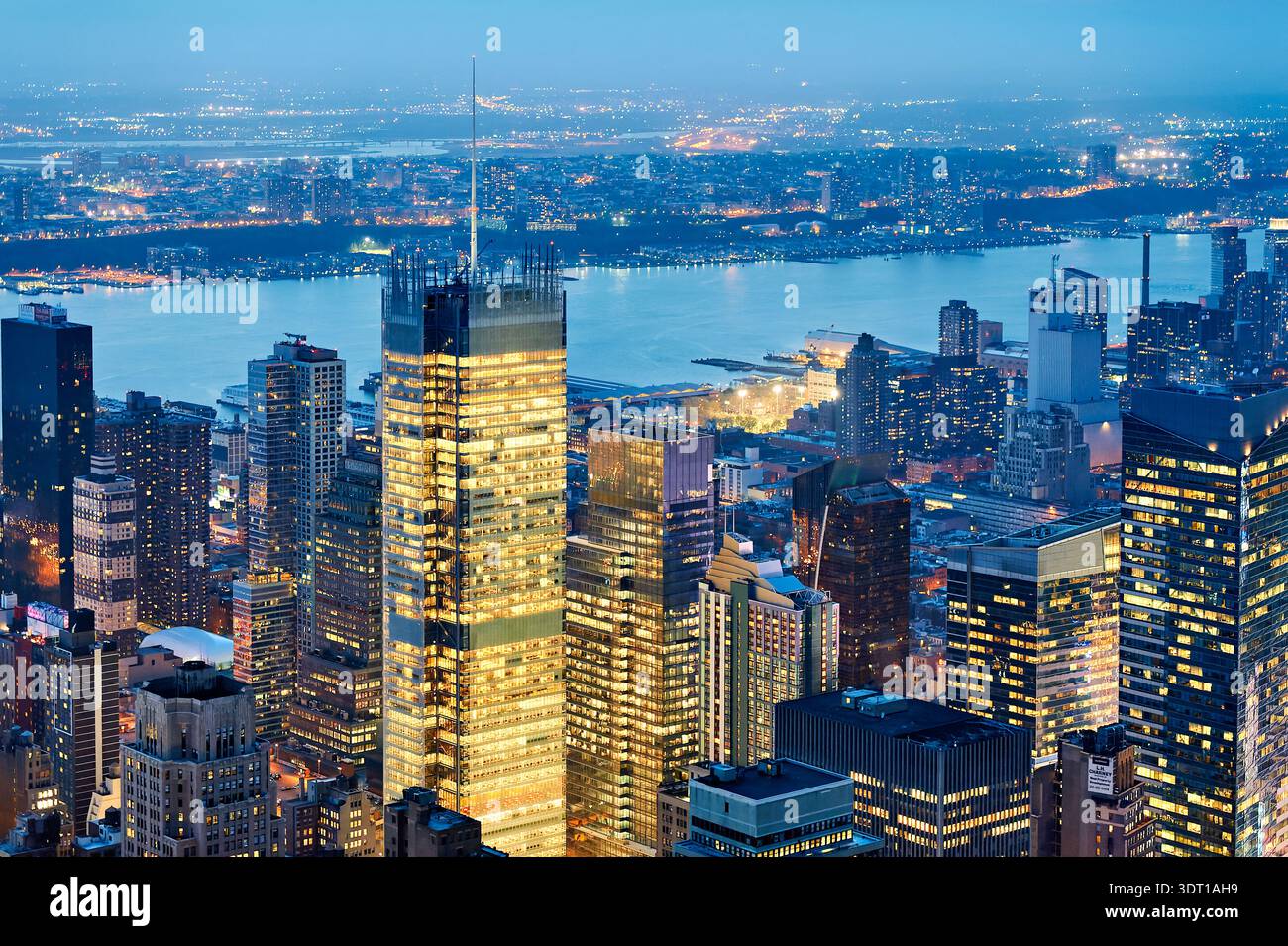 Lo skyline di Manhattan mostra edifici e luci al tramonto. La vista evidenzia il fiume e la disposizione della città man mano che si avvicina la notte. Foto Stock