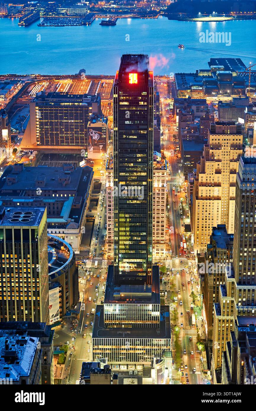 Manhattan al crepuscolo, che mostra le luci di edifici e strade mentre il fiume splende sotto il cielo serale. Foto Stock