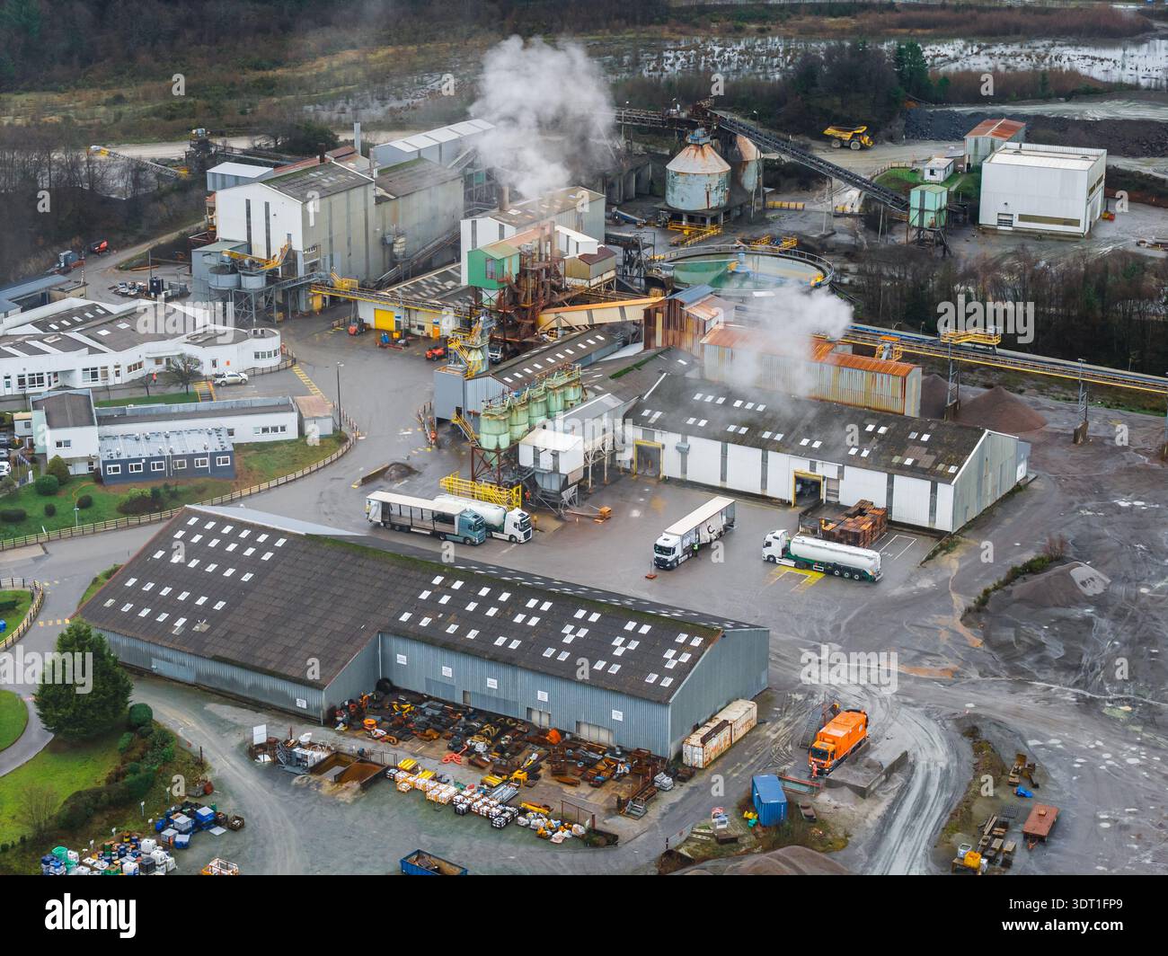 Vista aerea del complesso industriale con pennacchi di fumo che si innalzano sullo sfondo di verdi invernali silenziosi, Glomel, Bretagna, Francia. Foto Stock