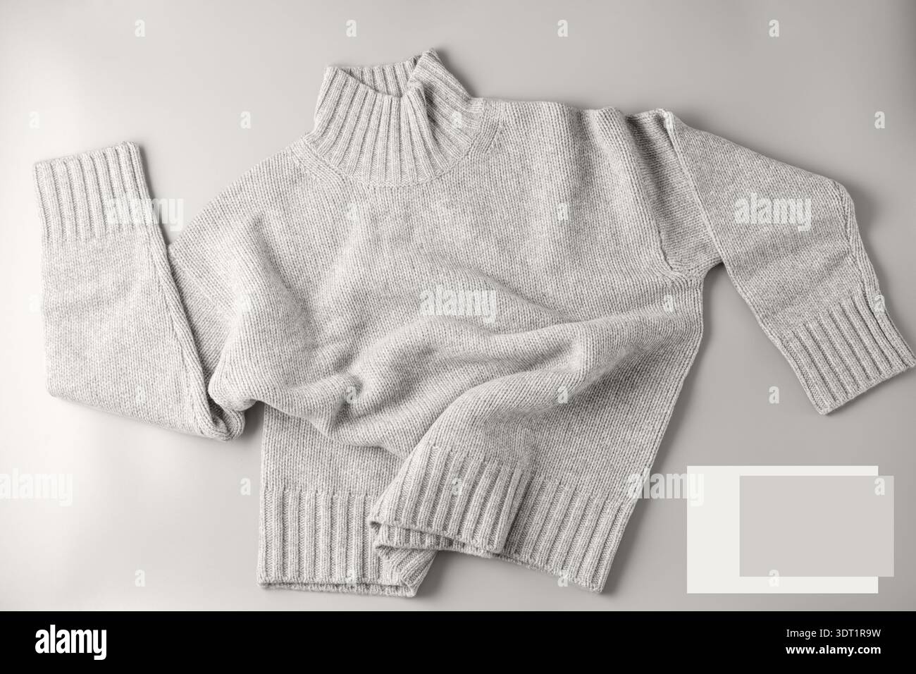 Morbido pullover di lana merino e cashmere in misto melange naturale grigio chiaro su sfondo neutro. Abbigliamento in pura lana in autunno e inverno in stile trendy c Foto Stock