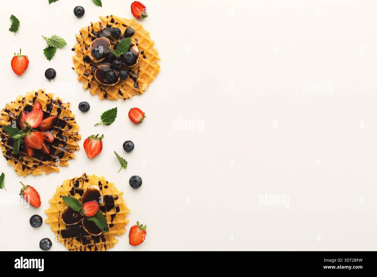 Collage di diversi dessert con waffle, frutta e salse al cioccolato su fondo piatto Foto Stock
