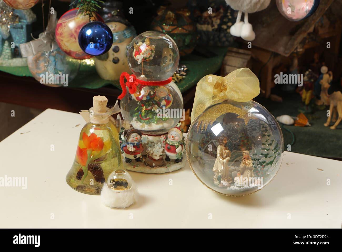 Globi di neve con babbo natale, pupazzi di neve e un presepe che creano decorazioni natalizie Foto Stock