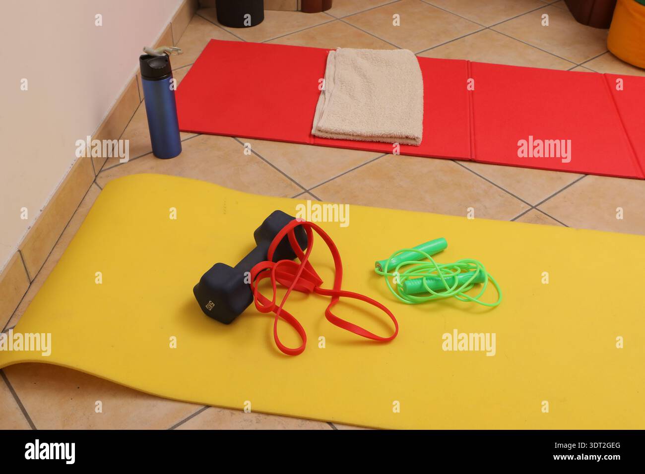 Attrezzature fitness su tappetini per yoga pronte per un allenamento al coperto Foto Stock