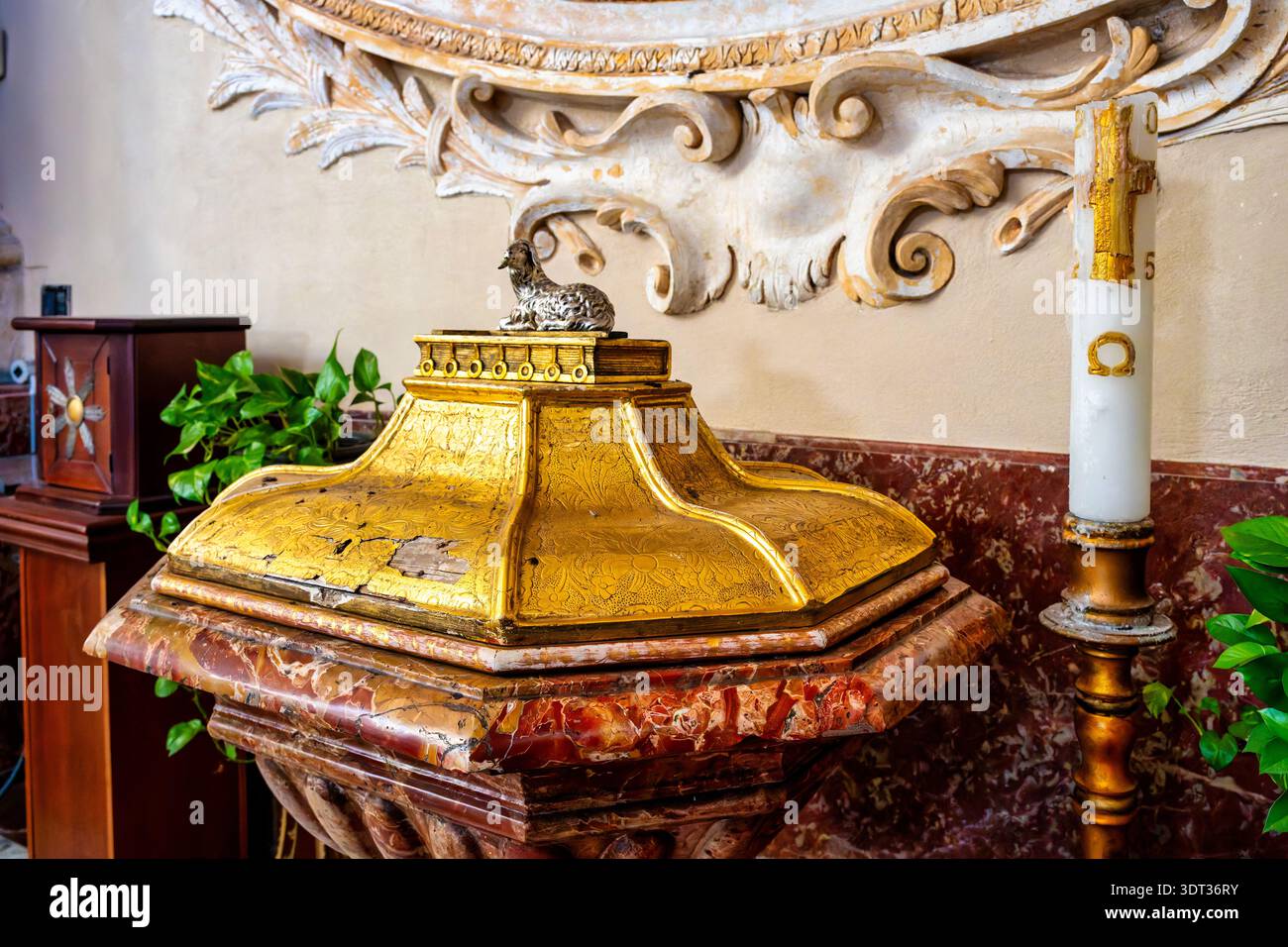 Fonte battesimale nella Basilica Cattedrale di Sant'Agata a Catania, Sicilia, Italia, con bacino in marmo rosso e copertura in legno sormontata da Agnus dei. Foto Stock