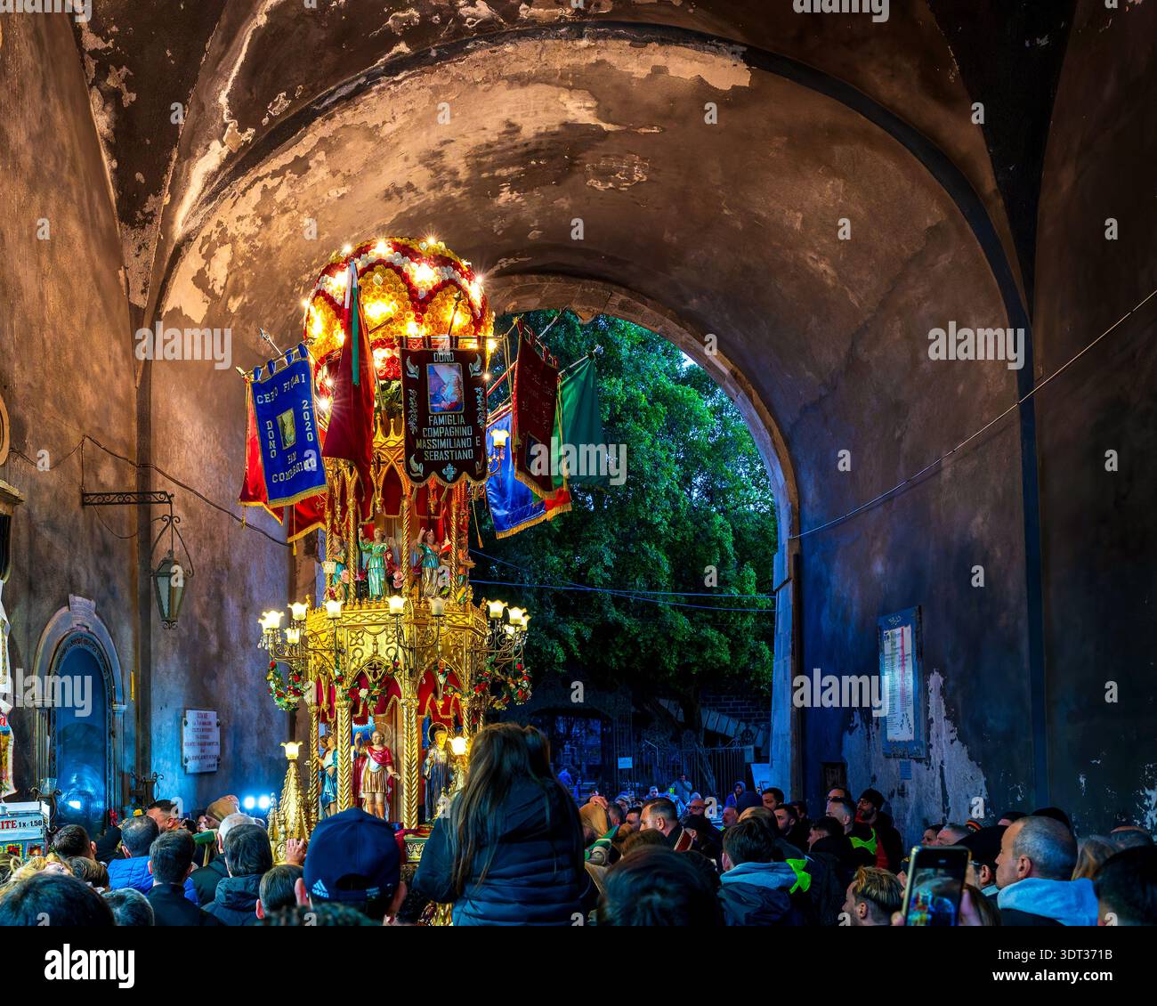 Cereo dei Fiorai (Giardiniera) a Catania, Sicilia, Italia passando sotto l'arco di porta Uzeda durante la processione della Festa di Sant'Agata al crepuscolo. Foto Stock