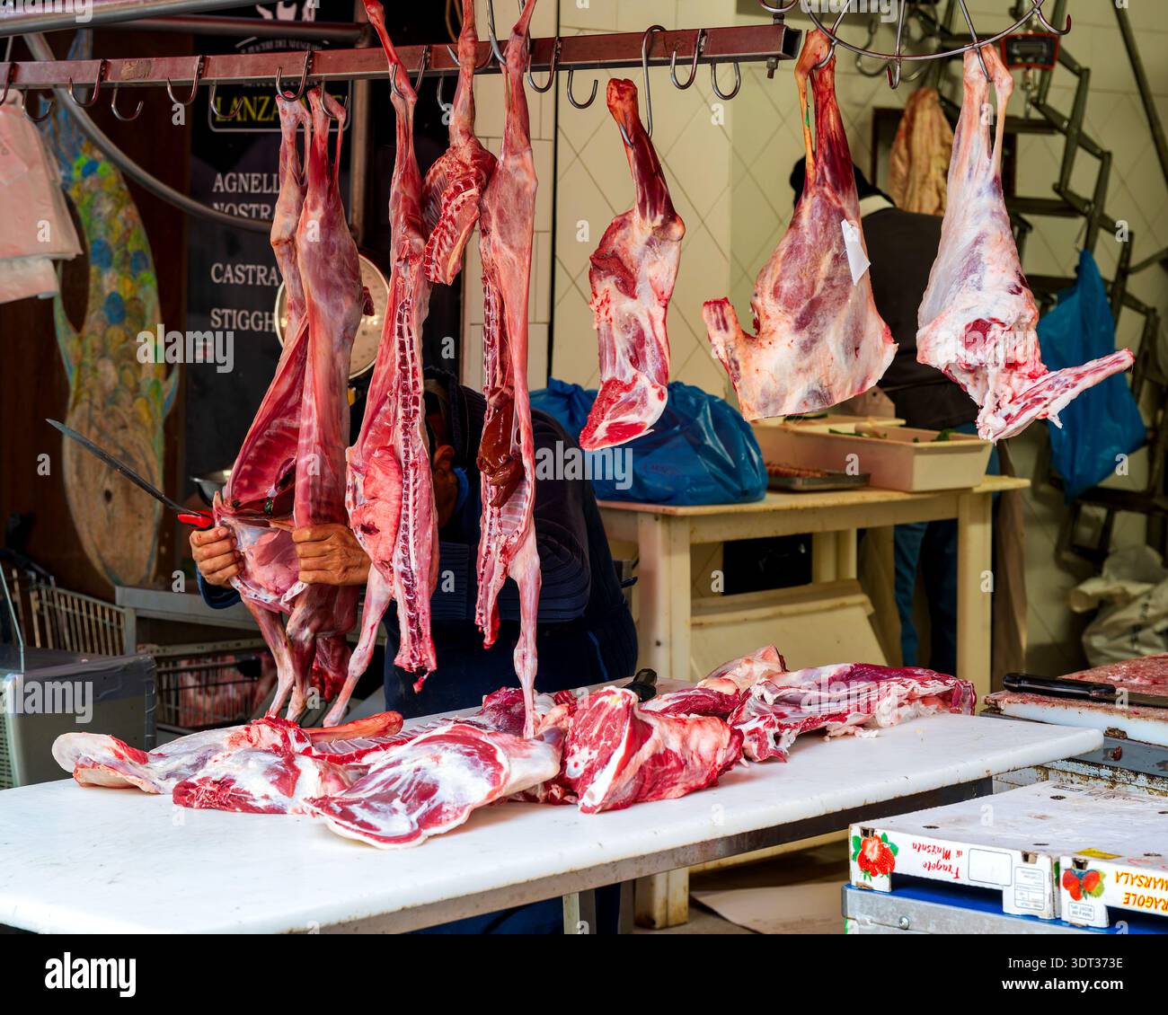 Macelleria vicino a la Pescheria a Catania, Sicilia, Italia con carcasse di carne appese. Foto Stock