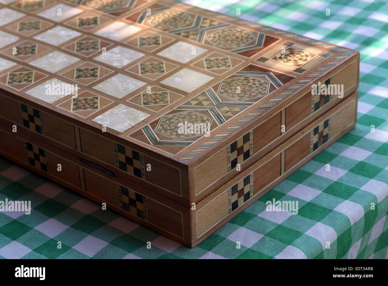 Tabellone di backgammon libanese chiuso, tawle, posto su un tavolo a scacchi verde. Foto Stock
