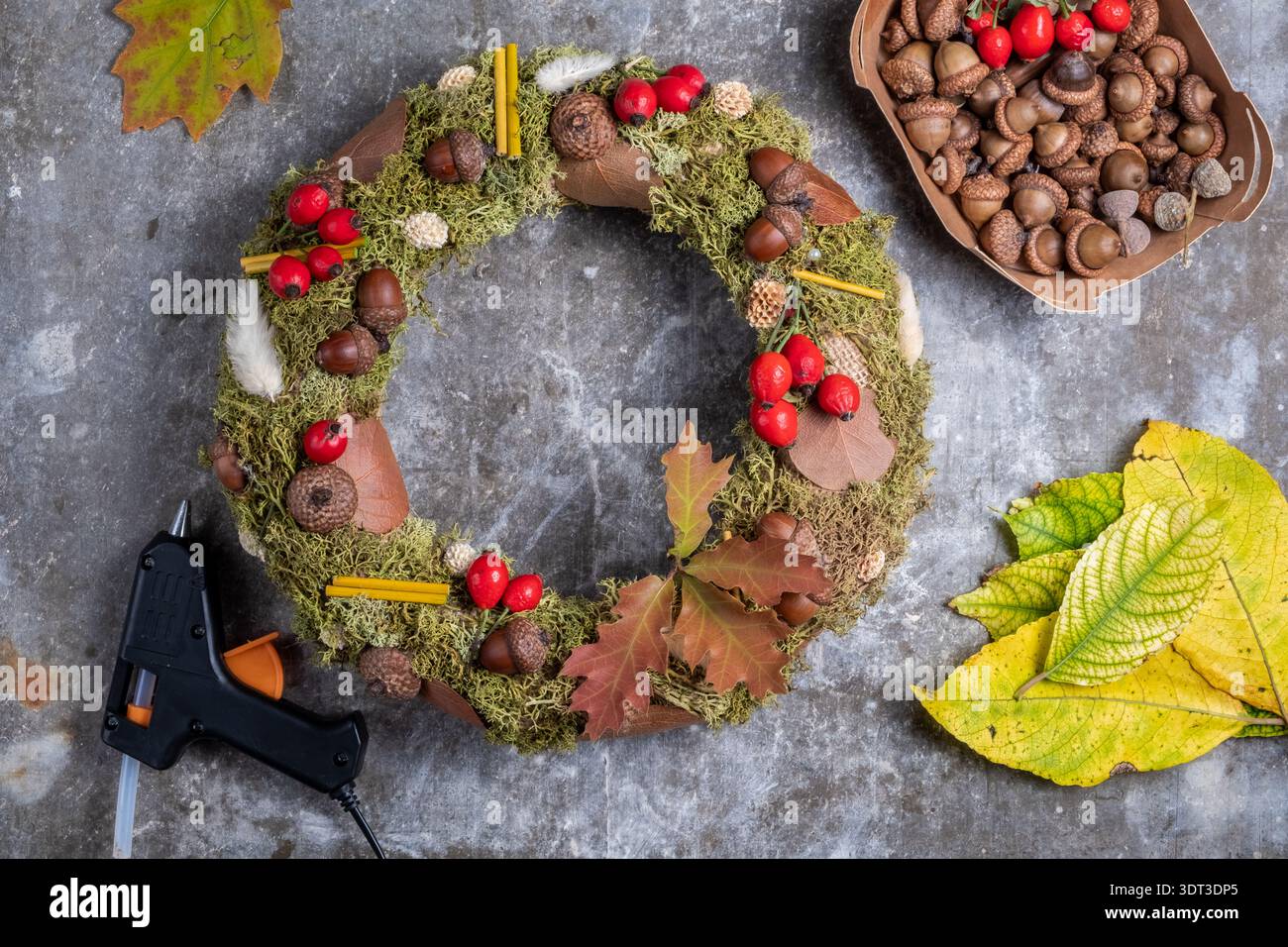 Corona autunnale realizzata a mano con materiali naturali su sfondo grigio. Arredamento per la casa autunnale. Foto Stock
