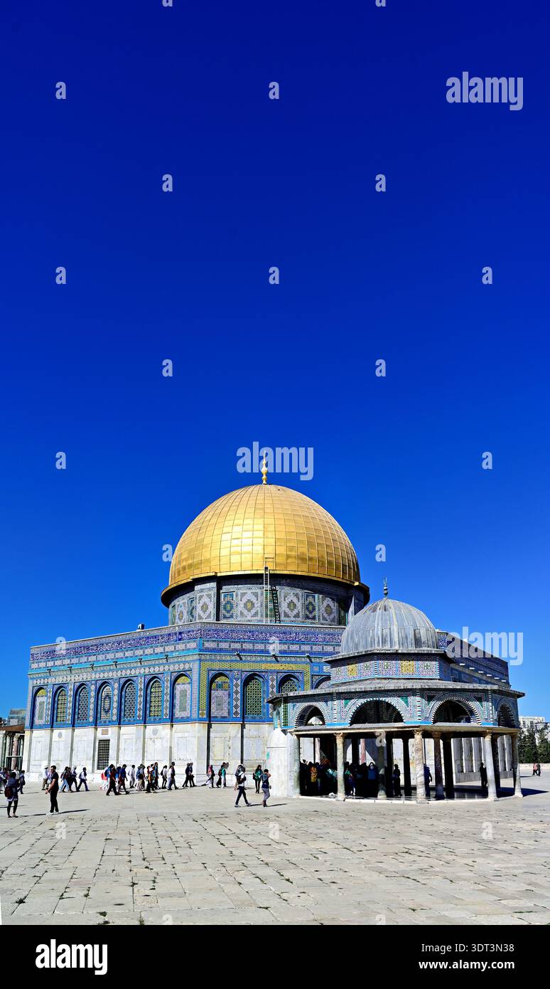 Le persone camminano intorno alla moschea della Cupola della roccia sul Monte del Tempio a Gerusalemme sotto un cielo azzurro chiaro durante le ore diurne. Foto Stock