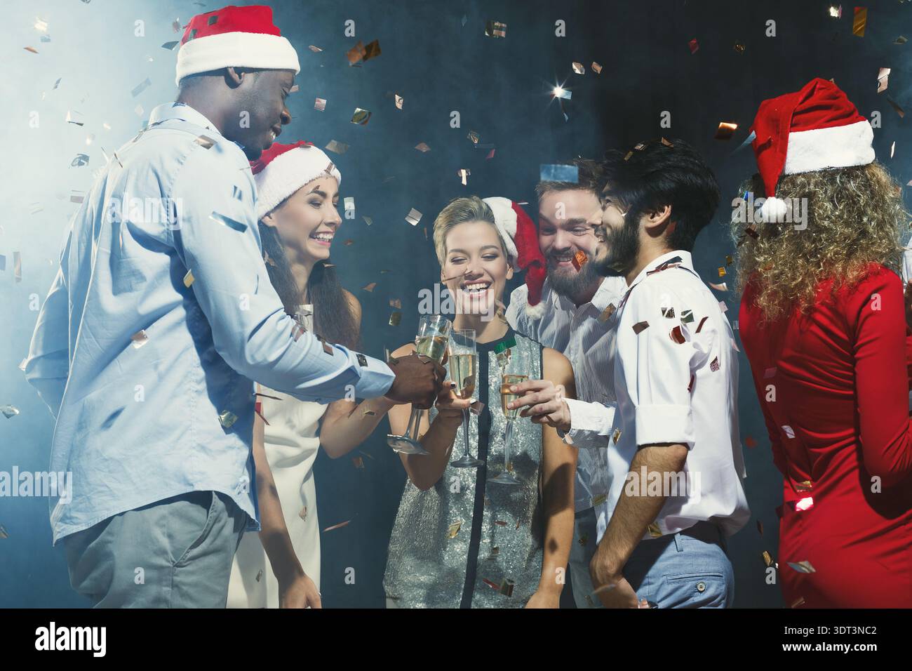 Festeggiamenti con gli amici in occasione di un raduno durante le festività natalizie con bevande e confetti Foto Stock