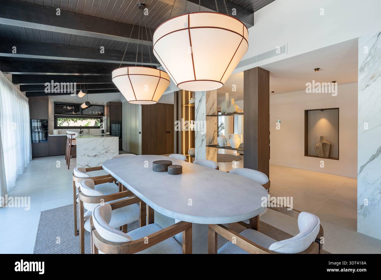 un'immagine di un tavolo di pietra di lusso accanto a una cucina aperta in una proprietà immobiliare mediterranea Foto Stock