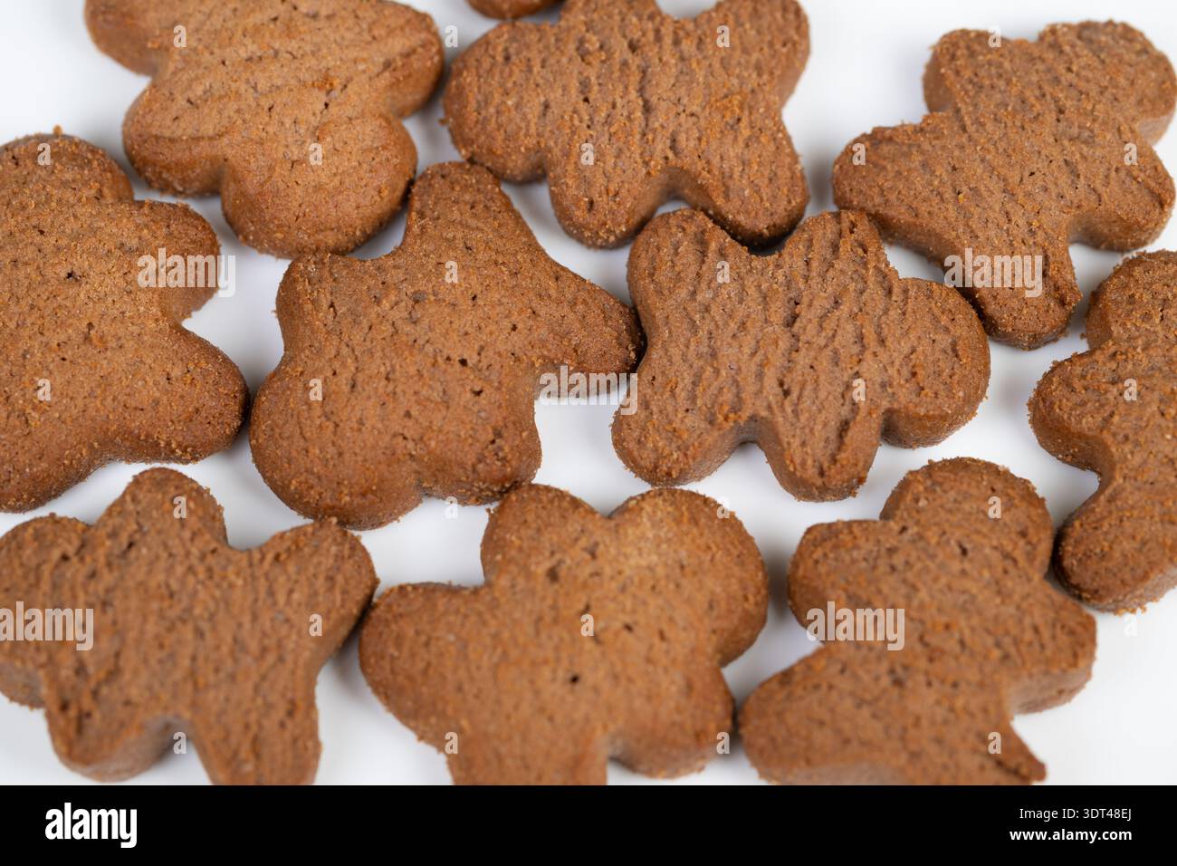 Assortimento di biscotti bianchi che mettono in risalto le forme di pan di zenzero fatte a mano con briciole rustiche, sottile lucentezza dello zucchero, toni caldi e dettagli macro precisi, ideale per Foto Stock