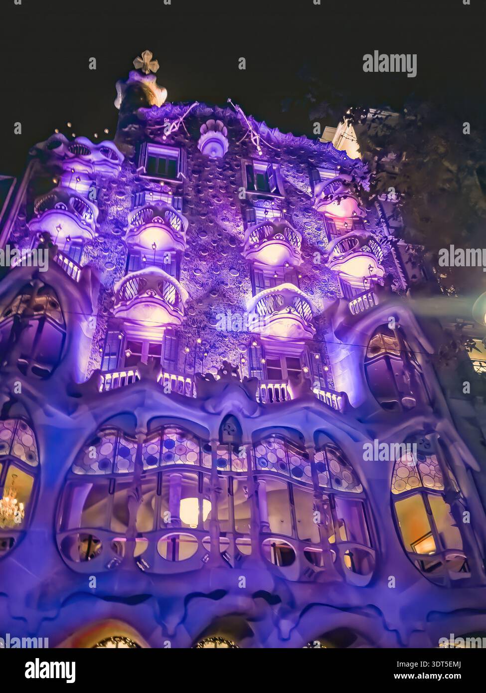Barcellona, Spagna - 26 novembre 2021: Illuminazione viola delle pareti di Casa Batllo di Antoni Gaudí di notte a Barcellona. Illuminazione festiva blu - Immagine stock catturata con smartphone