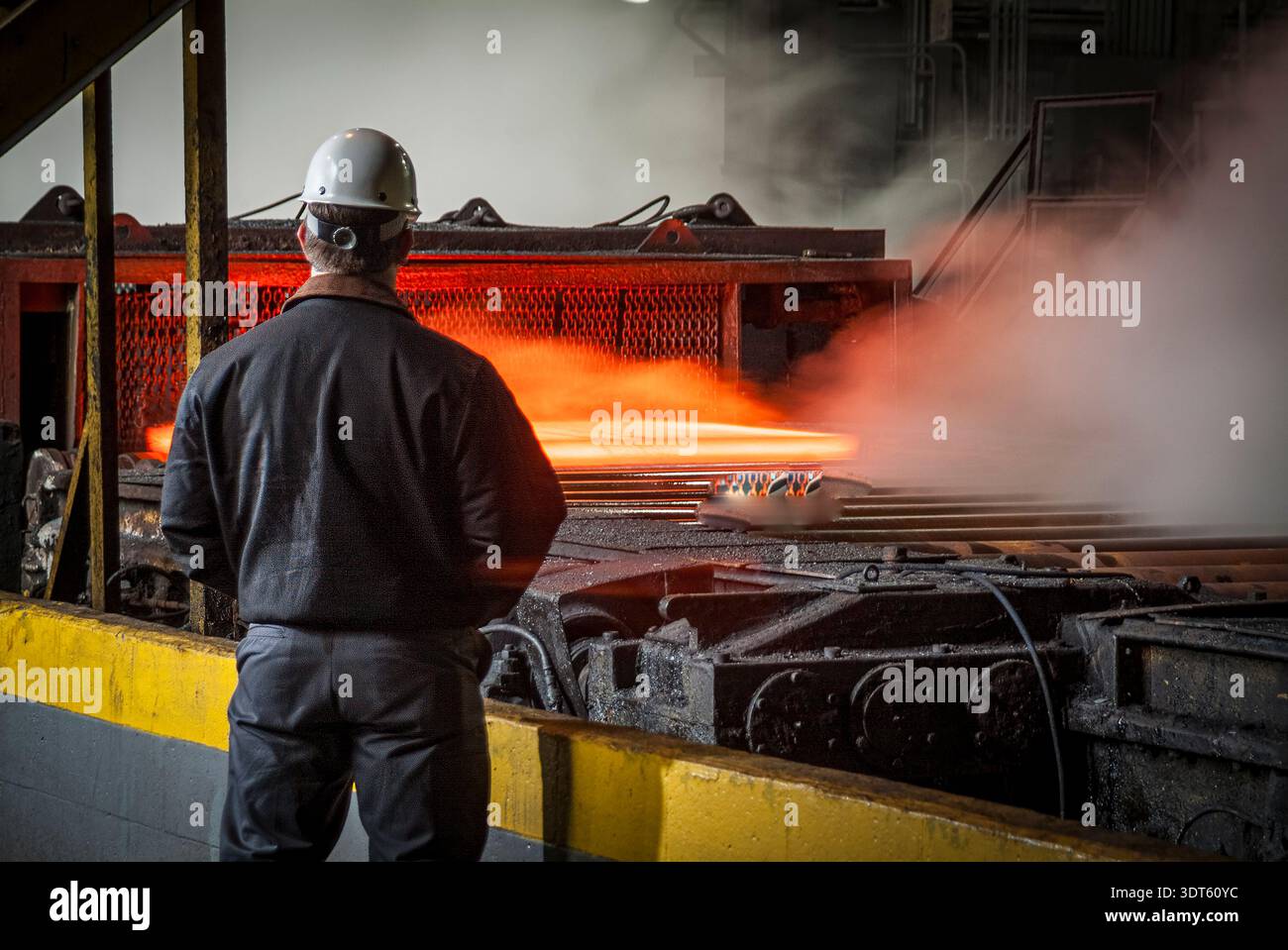 Supervisore che ispeziona le piastre di acciaio a caldo durante il processo di produzione dell'acciaieria, Pittsburgh, Pennsylvania, Stati Uniti Foto Stock