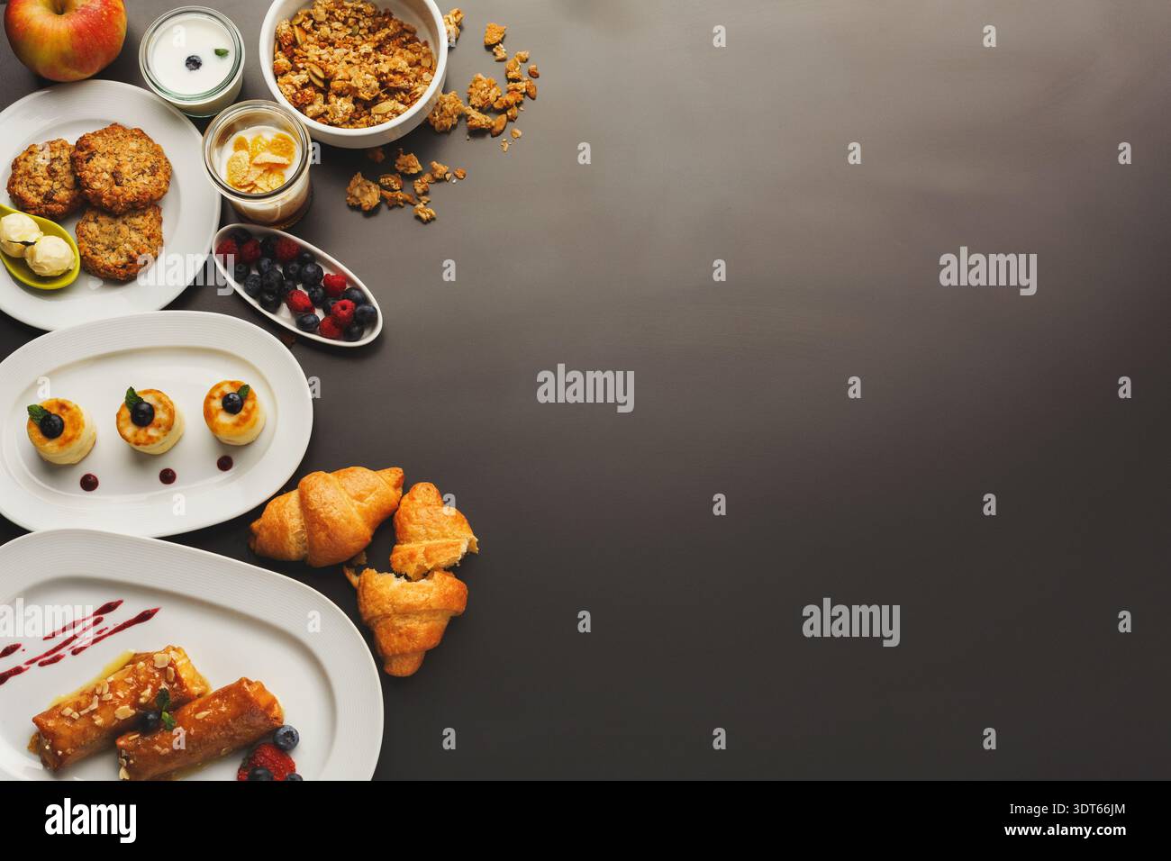 Colazione con vari cibi collocati su una superficie scura Foto Stock