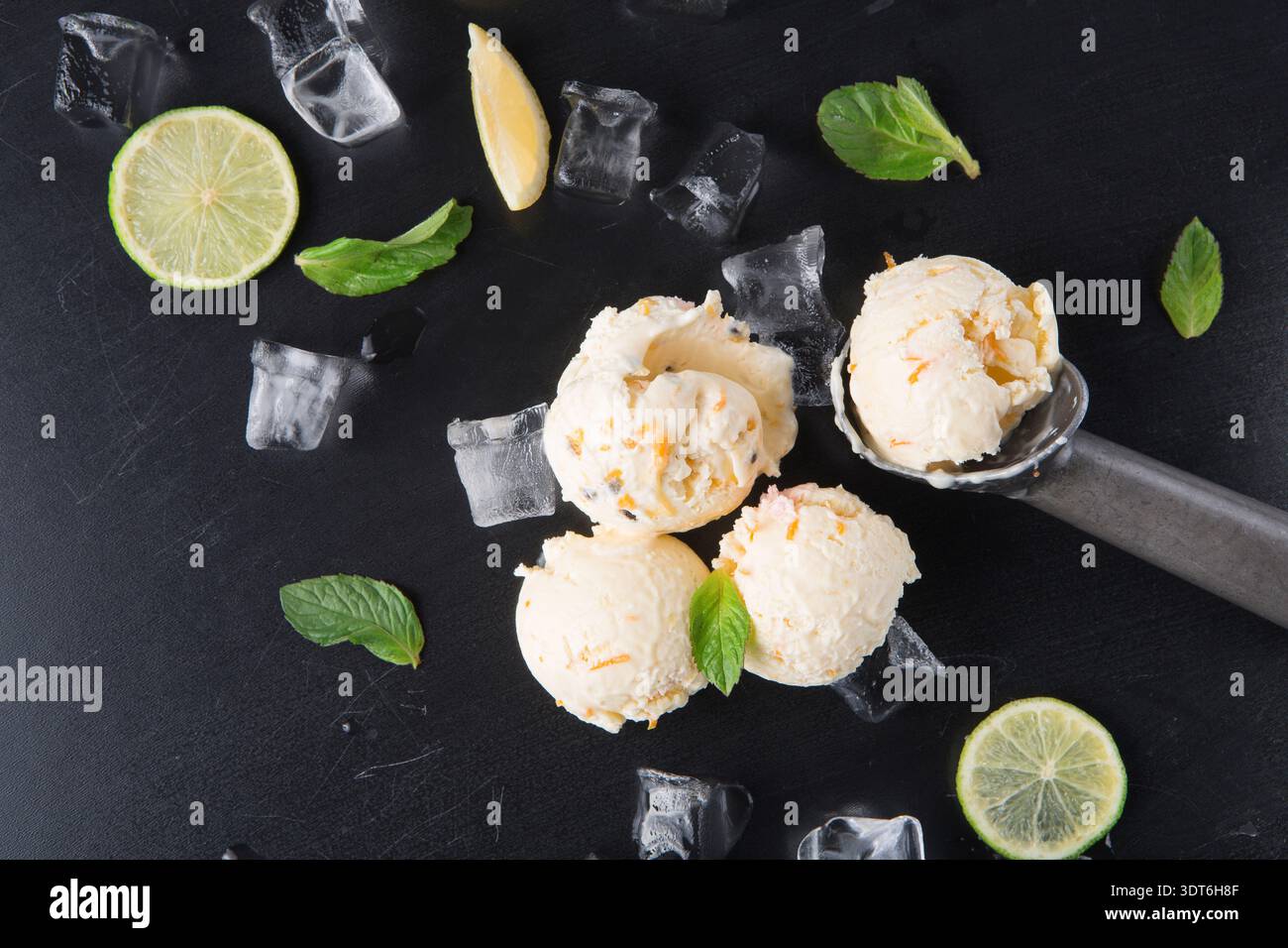Gelato estivo con menta e agrumi su sfondo nero con luce pomeridiana Foto Stock