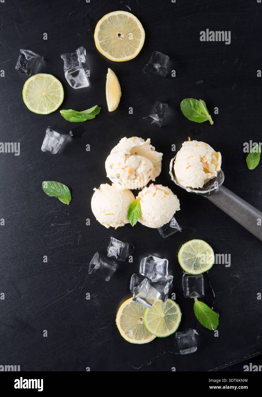 Gelato con limone, menta e ghiaccio su superficie nera durante il pomeriggio estivo Foto Stock