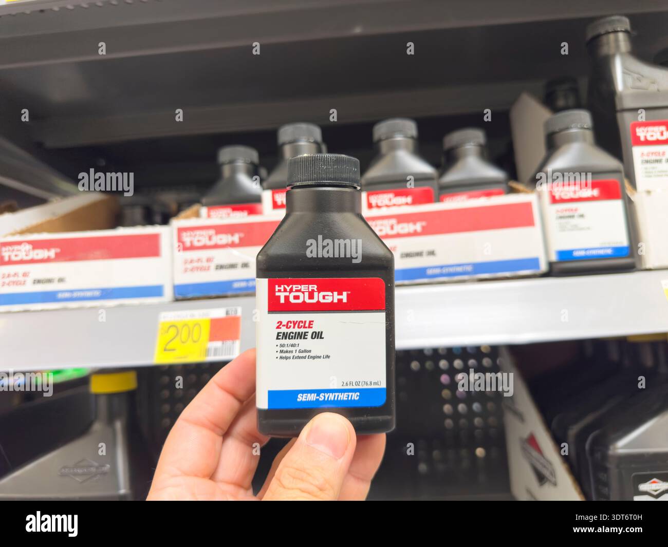 Los Angeles, California, Stati Uniti - 04-14-2024: Una vista di una mano che tiene una bottiglia di olio motore Hyper Tough, in mostra presso un negozio al dettaglio locale. Foto Stock