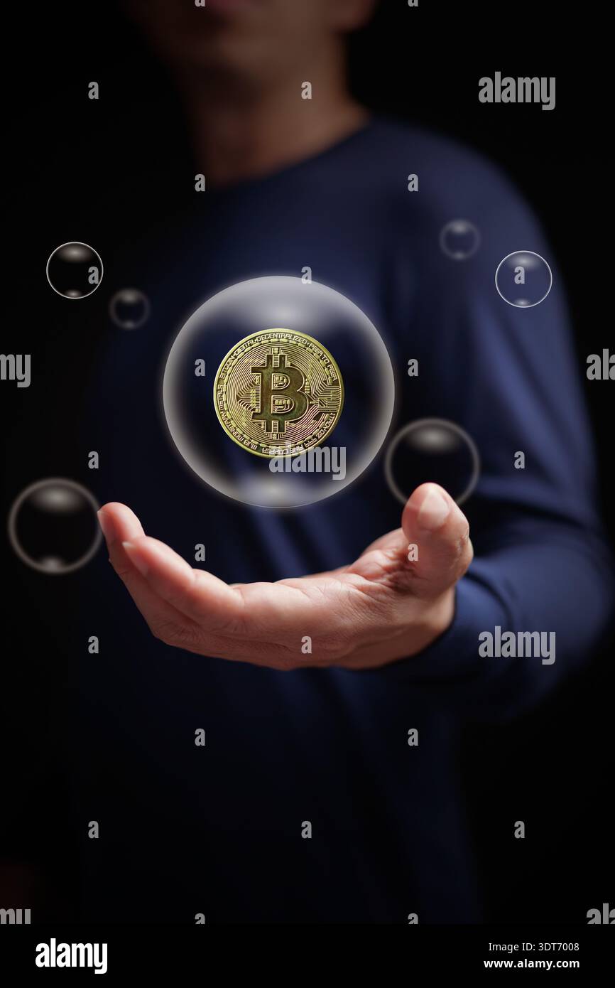 Concetto di bolla AI con moneta di criptovaluta Bitcoin dorata che galleggia all'interno di bolle trasparenti sopra la mano. Possibile scoppio in intelligen artificiale Foto Stock