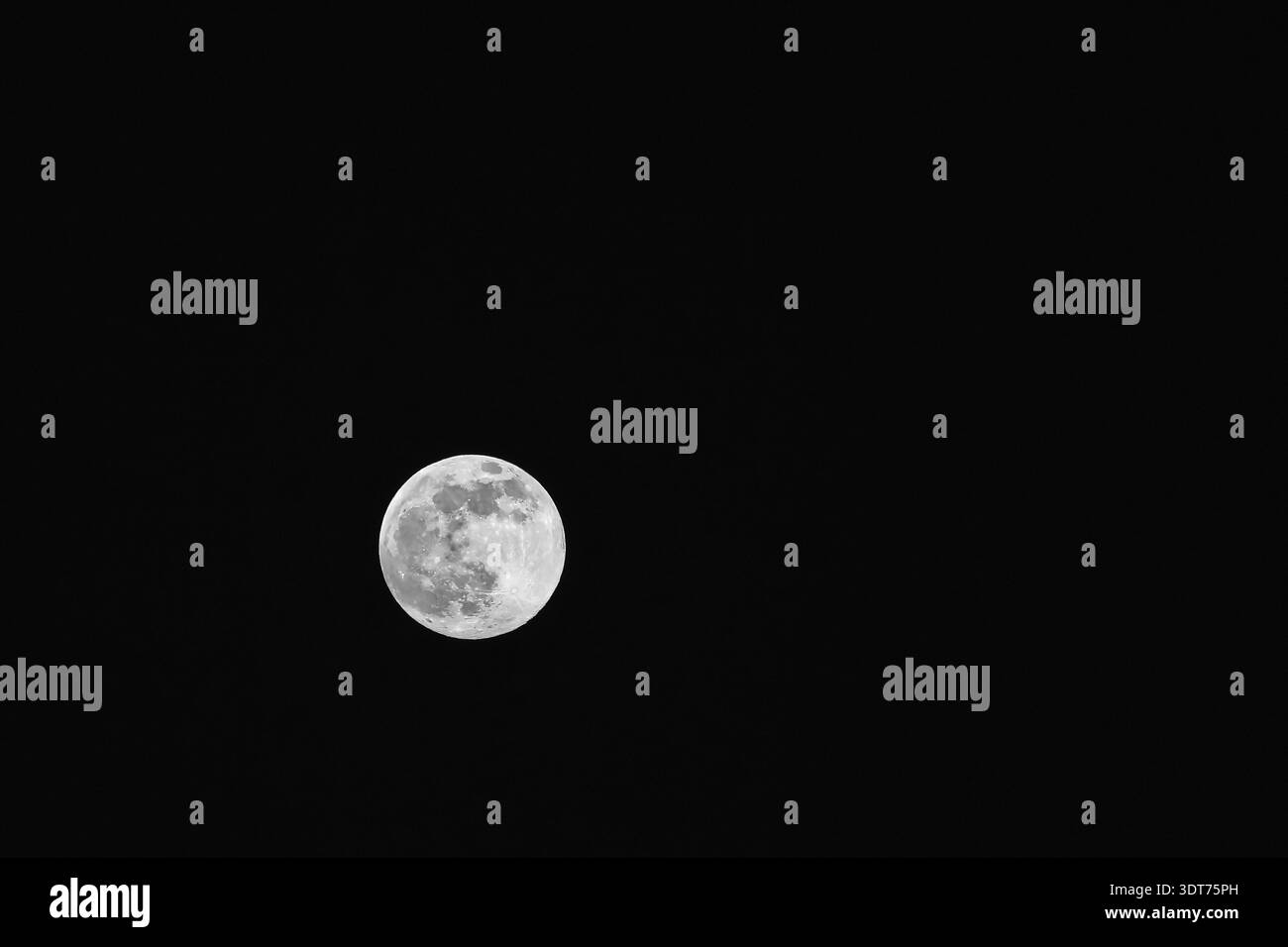 La luna splende brillantemente nel cielo notturno Foto Stock