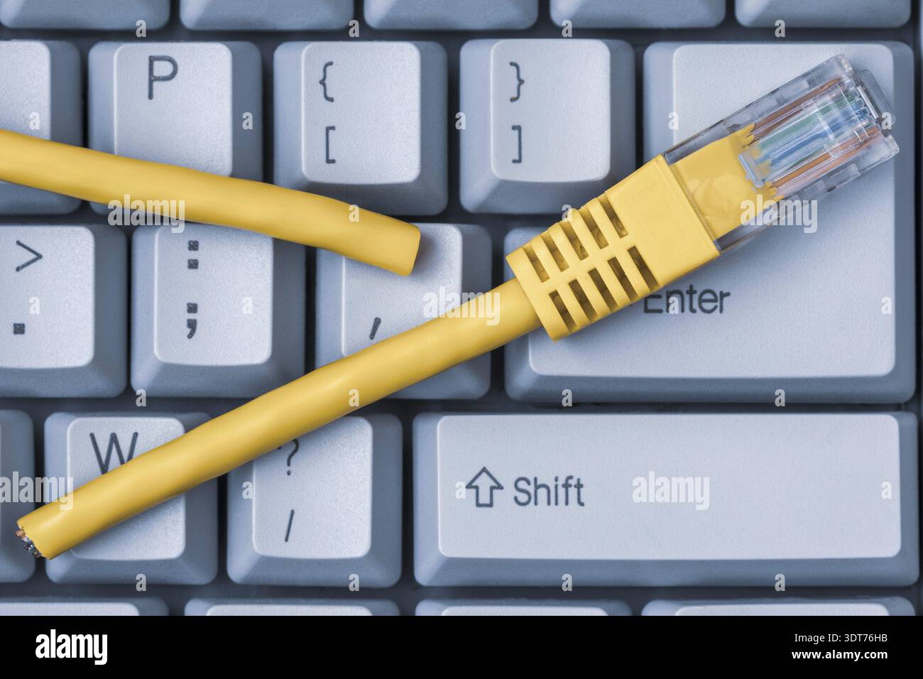 Connessione Internet disconnessa. Tastiera blu del computer con cavo di rete giallo interrotto Foto Stock