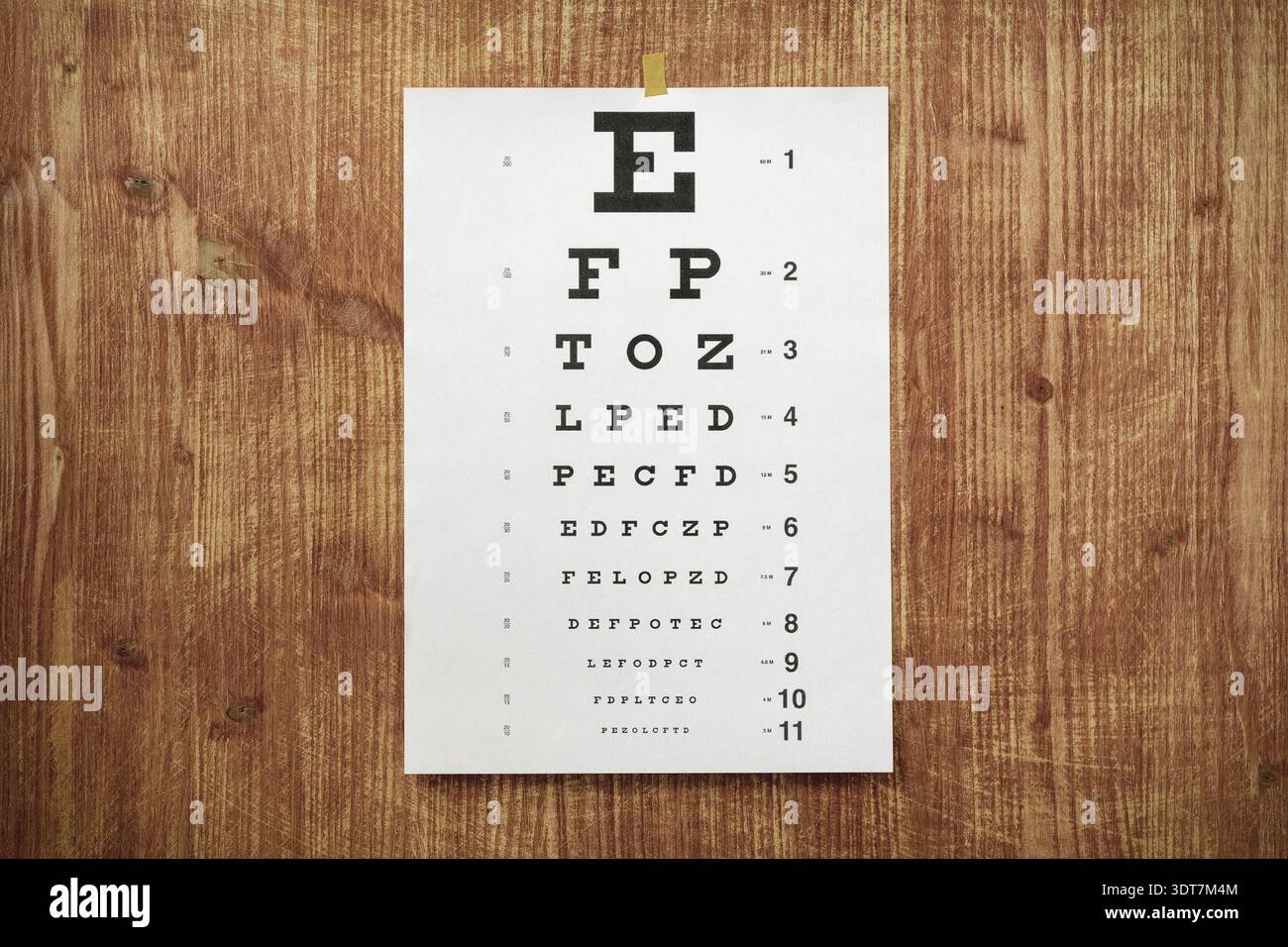 Tabella dei test oculari - grafico ottico bianco sulla parete in legno Foto Stock
