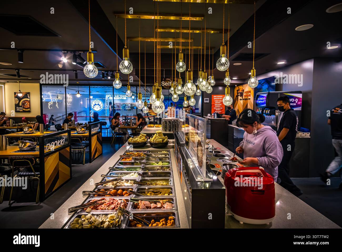 Dookki Singapore Korean Tteokbokki buffet al Suntec City, Singapore, mostrando ai clienti il banco di ristorazione self-service. Foto Stock