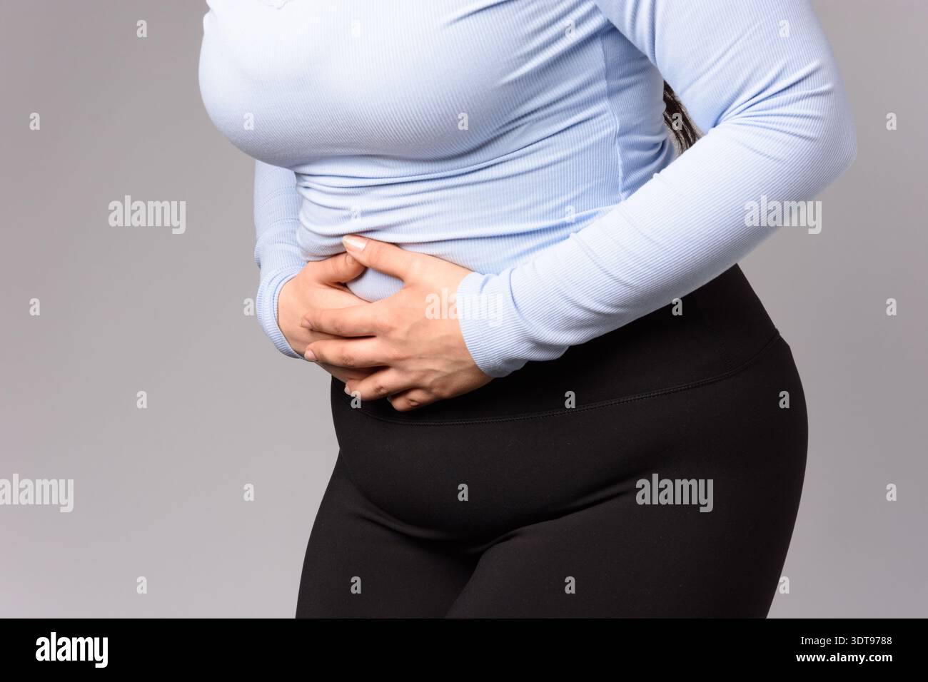 Immagine di una giovane donna con mestruazioni mal di stomaco dolore problemi di stringere lo stomaco. Malattia addominale del ventre nella persona femminile. Foto Stock