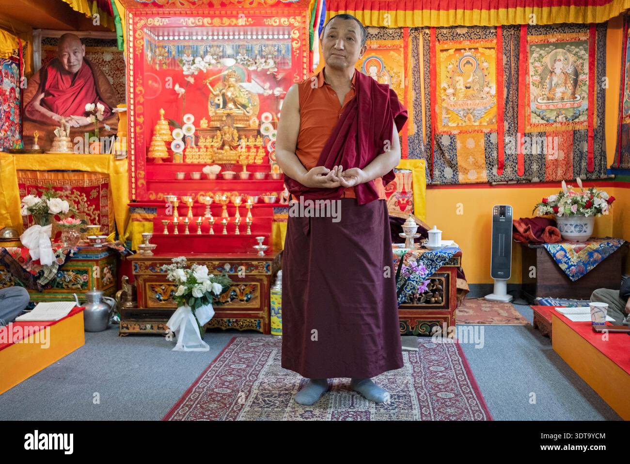 Un monaco di una congregazione Sherpa lezioni la sua congregazione in Nepalese tibetano e su gesti con le mani durante la preghiera. In Elmhurst, Queens, a New York City. Foto Stock