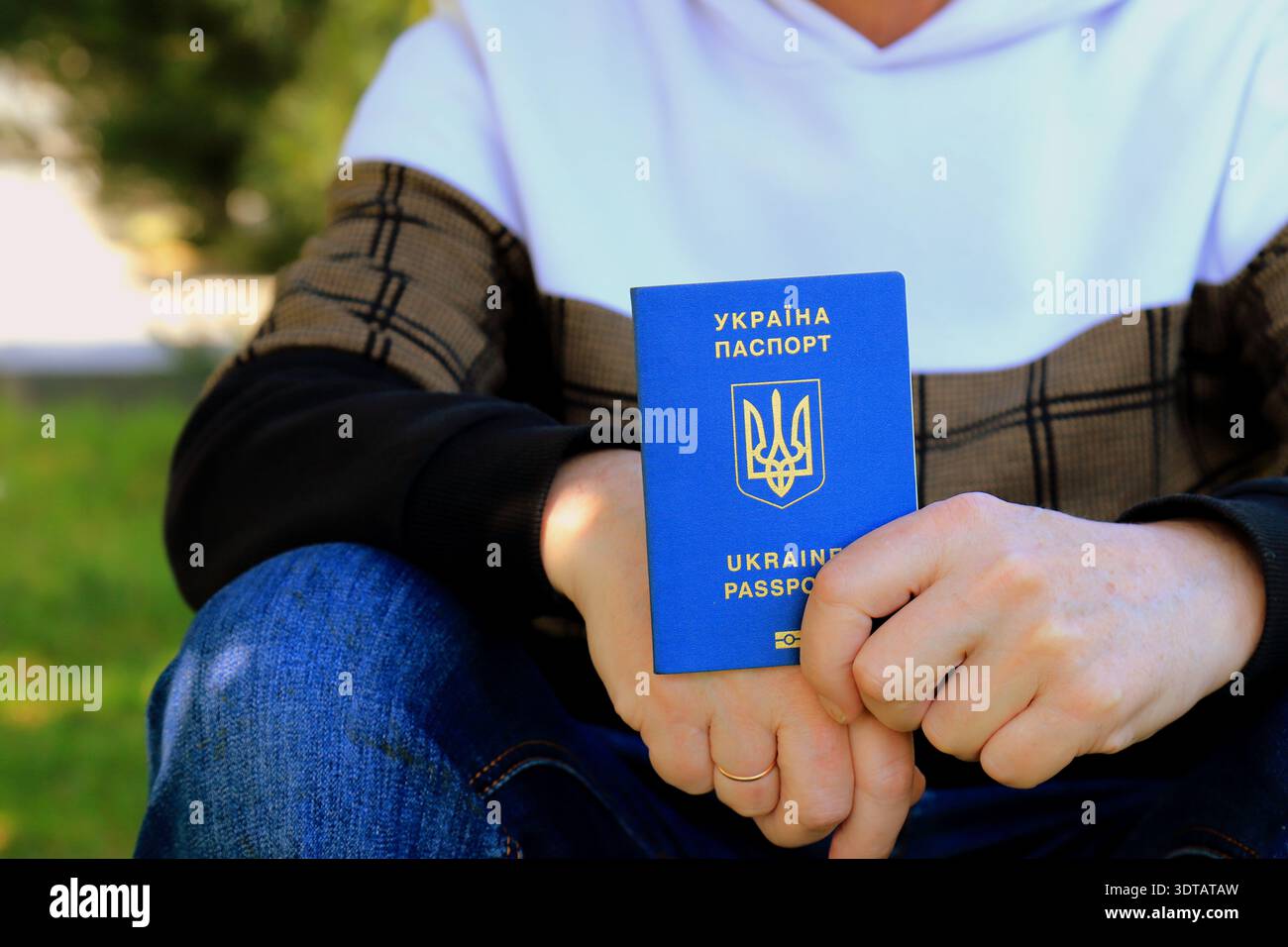 Un uomo ha un passaporto ucraino con un'iscrizione in ucraino - passaporto dell'Ucraina. Concetto di viaggio, rifugiato, turista, emigrante, mobilitazione, mig Foto Stock