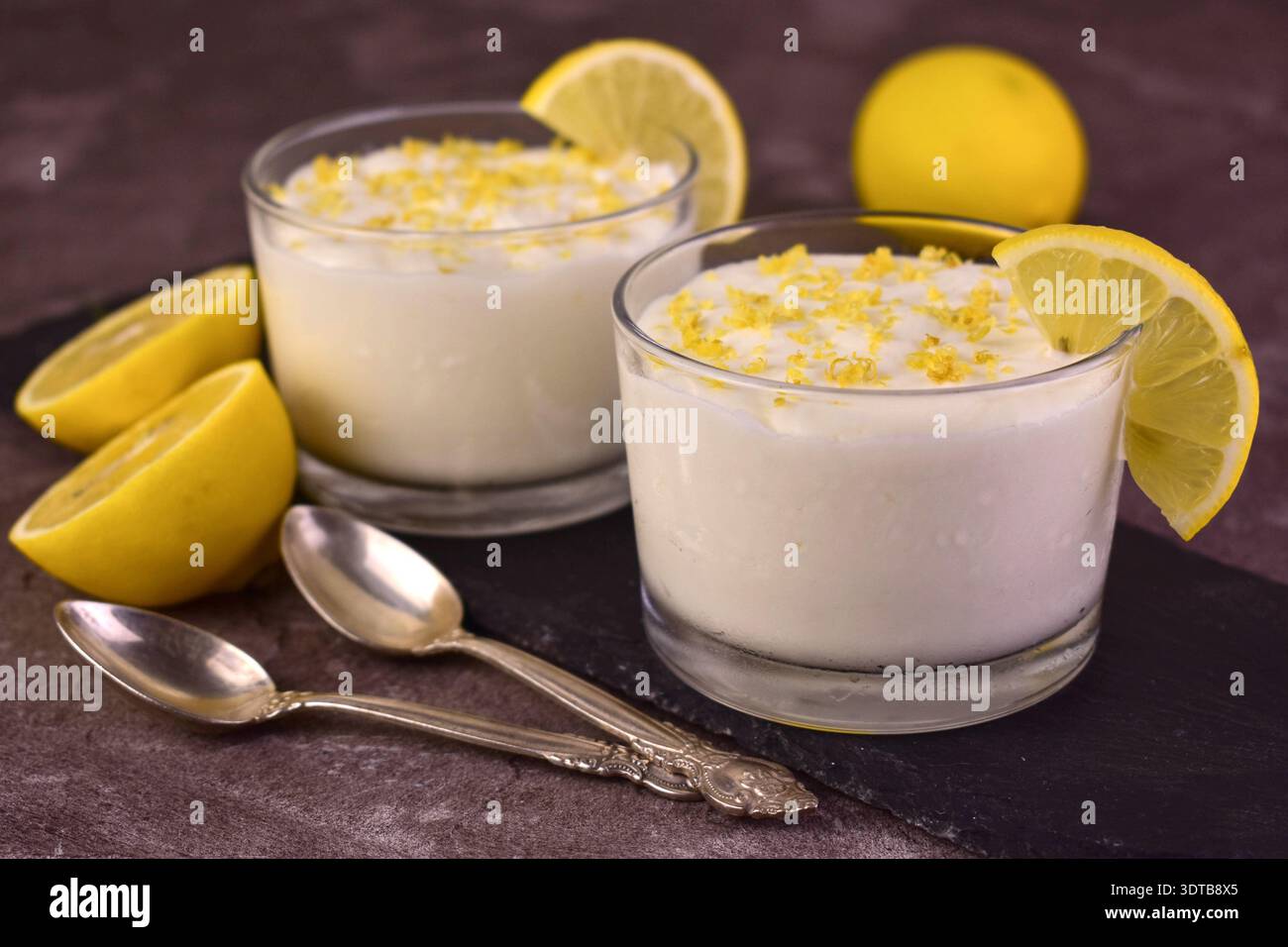 Dolce e aspro, dolce e cremoso dessert al limone in un bicchiere. Foto Stock