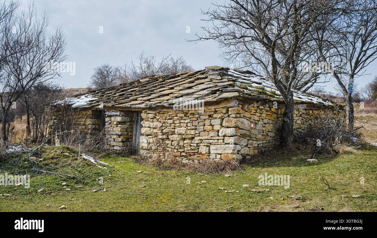 Vecchia capanna di montagna abbandonata e in rovina costruita solo con rocce, edificio in stile tradizionale nella storia serba Foto Stock