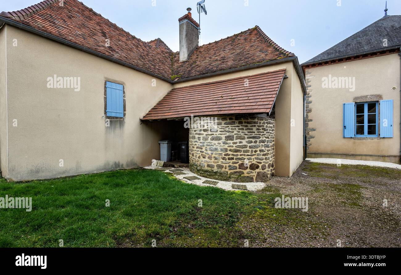 Accogliente cortile di una casa residenziale a un piano con un prato verde e un'area designata per i contenitori dei rifiuti. Questo giardino privato mostra Foto Stock
