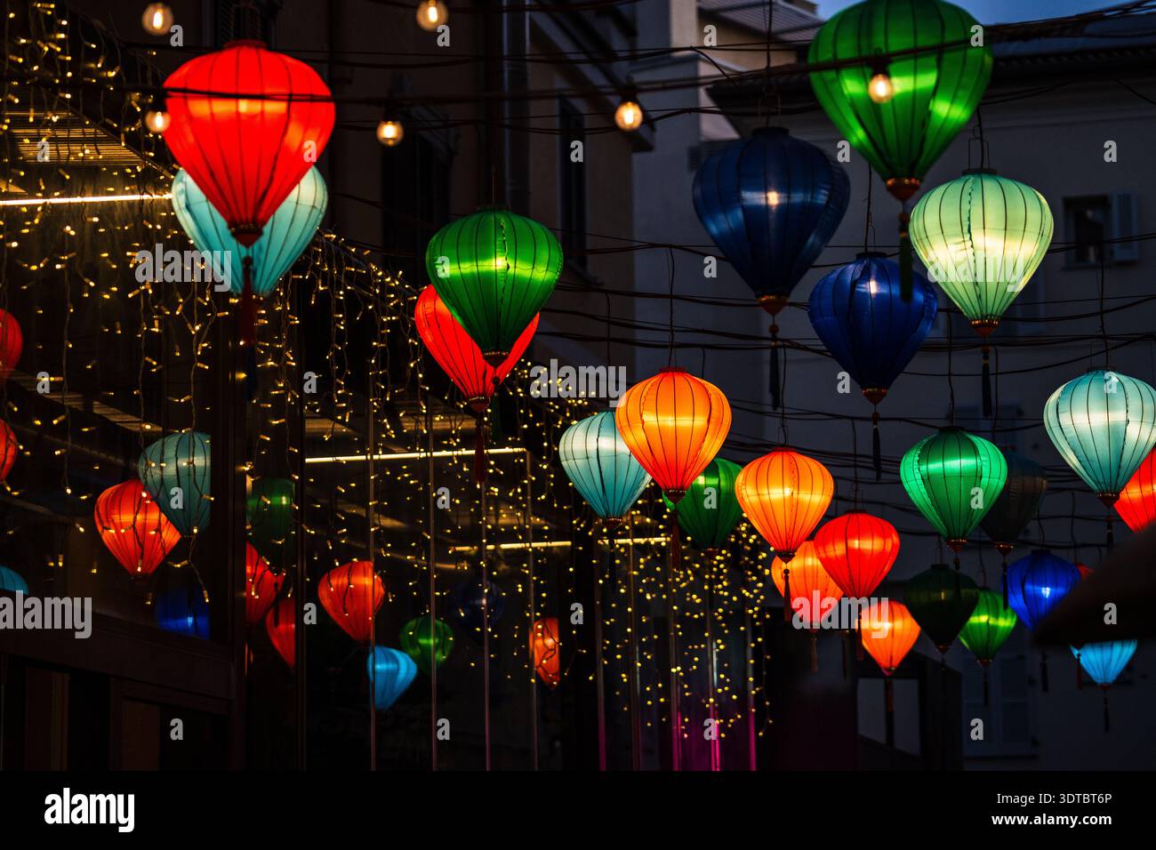 Vista ravvicinata di centinaia di lanterne di seta multicolore (rosse, verdi, blu, arancioni) che decorano via Paolo Sarpi a Milano durante il Capodanno lunare Foto Stock
