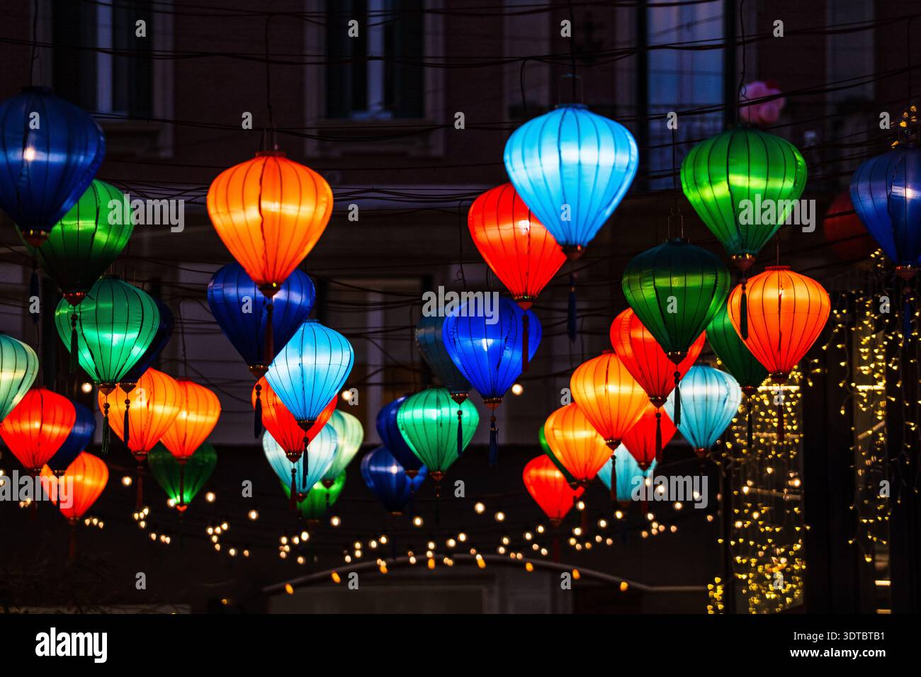 Vista ravvicinata di centinaia di lanterne di seta multicolore (rosse, verdi, blu, arancioni) che decorano via Paolo Sarpi a Milano durante il Capodanno lunare Foto Stock