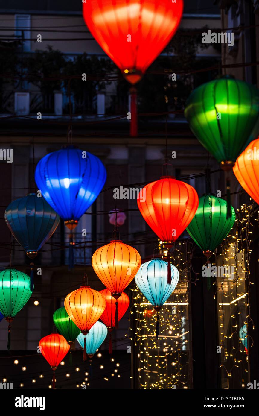 Vista ravvicinata di centinaia di lanterne di seta multicolore (rosse, verdi, blu, arancioni) che decorano via Paolo Sarpi a Milano durante il Capodanno lunare Foto Stock