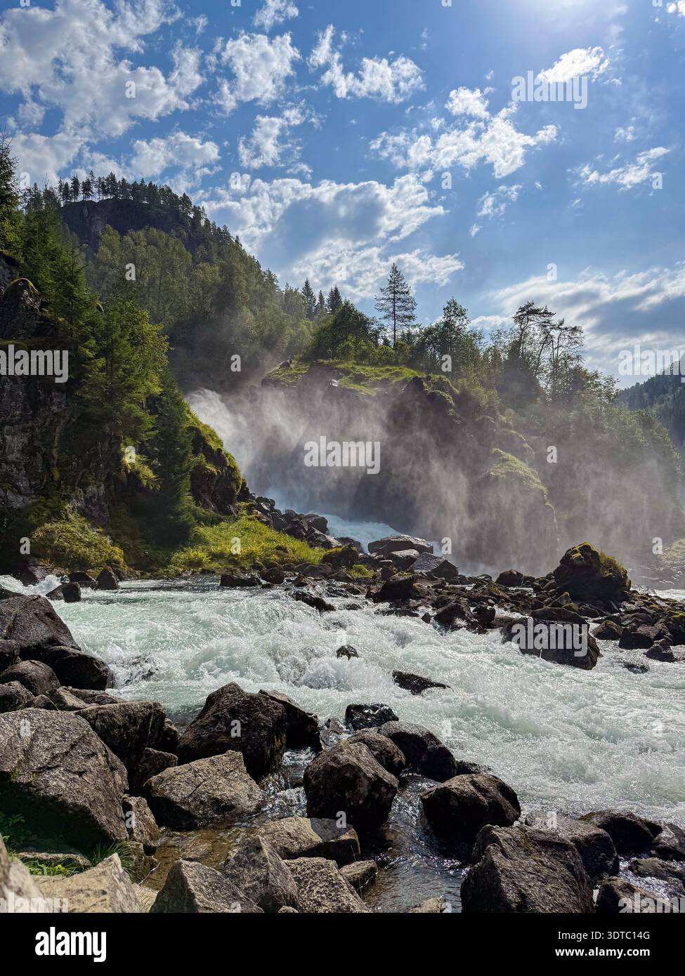 Potente cascata che crea nebbia nel paesaggio norvegese Foto Stock