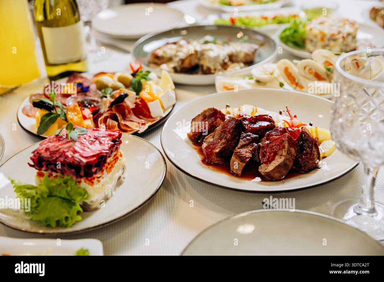 Carne alla griglia con salsa servita su un elegante tavolo da pranzo Foto Stock